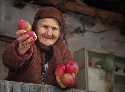 A Romanian villager sharing a few apples from her garden.