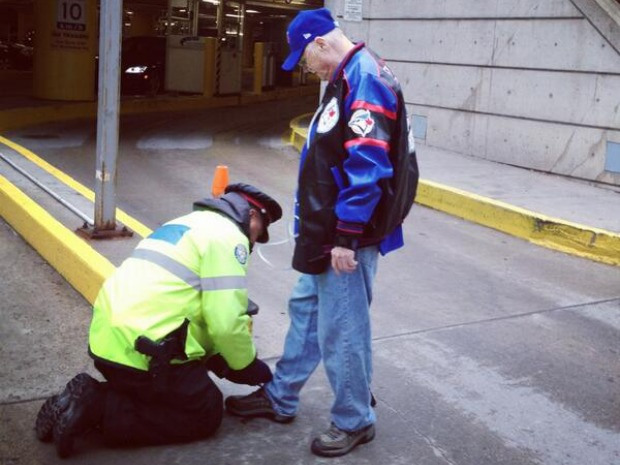 Policeman Tying an Old Man's Shoes
