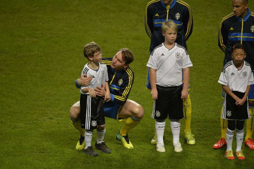A member of the Swedish national team consoles a frightened autistic child at a game against Germany