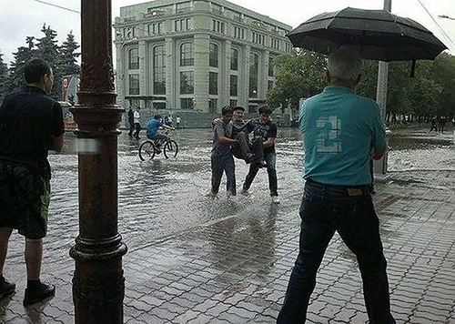 These young men carried an elderly man across a flooded street. (Photo via Web of Good News)
