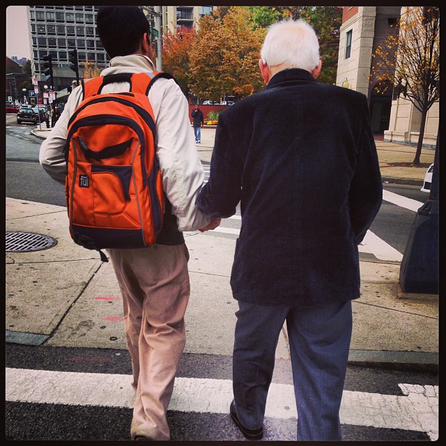 helping an elderly man across the street