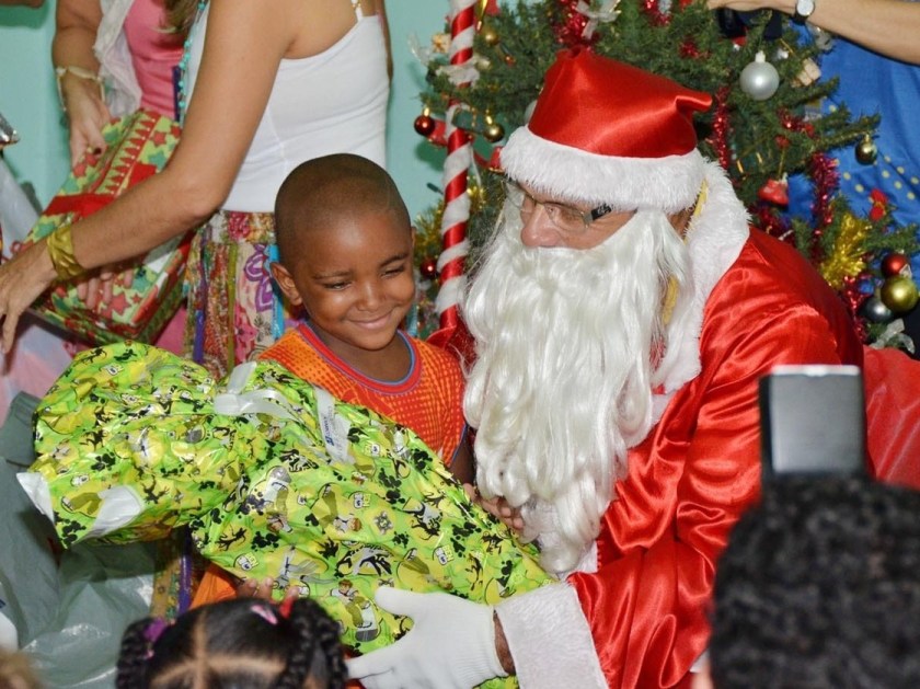 A man dressed as Santa Claus, representing the Brazilian postal service, distributes gifts donated to needy children in a public elementary school in Salvador, Brazil.