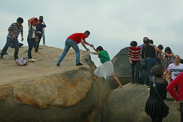 People believe that standing on top of this rock will bring good fortune. It was the most beautiful scene to see the kindness of people.