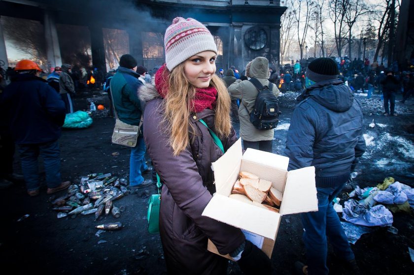 Ukrainian girl giving sandwiches to protesters 