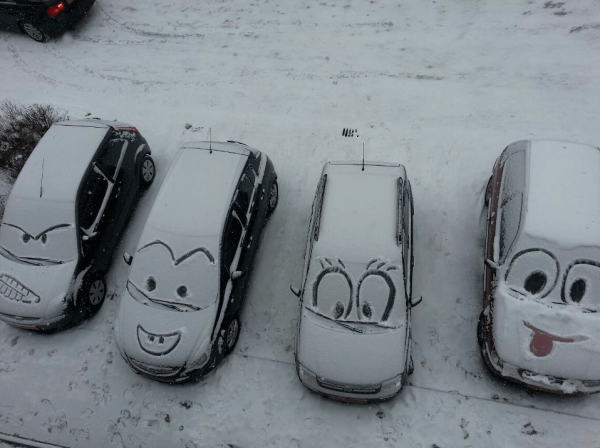 kindness - person sculpts smiley faces in the snow on cars