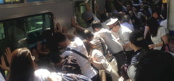 Train passengers and railway staff push a train car to rescue a trapped woman at Minami Urawa station. Photograph: Norihiro Shigeta/AP Dozens of Japanese commuters pushed a 32-tonne train carriage away from the platform to free a woman who had fallen into the 20cm (8in) gap between it and the platform. The act of collective heroism was captured by a newspaper photographer. A public announcement that a passenger was trapped prompted about 40 people to join train officials to push the carriage, whose suspension system allows it to lean to either side, the Yomiuri newspaper reported. The unnamed woman in her 30s was then pulled out uninjured to applause from onlookers at JR Minami-Urawa station, just north of Tokyo. After just an eight-minute delay, the train went on its way.