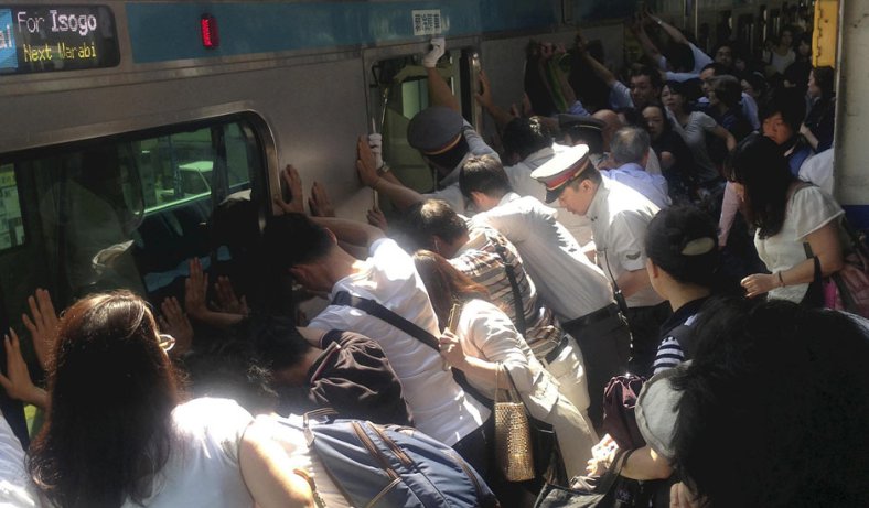 Train passengers and railway staff push a train car to rescue a trapped woman at Minami Urawa station. Photograph: Norihiro Shigeta/AP Dozens of Japanese commuters pushed a 32-tonne train carriage away from the platform to free a woman who had fallen into the 20cm (8in) gap between it and the platform. The act of collective heroism was captured by a newspaper photographer. A public announcement that a passenger was trapped prompted about 40 people to join train officials to push the carriage, whose suspension system allows it to lean to either side, the Yomiuri newspaper reported. The unnamed woman in her 30s was then pulled out uninjured to applause from onlookers at JR Minami-Urawa station, just north of Tokyo. After just an eight-minute delay, the train went on its way.
