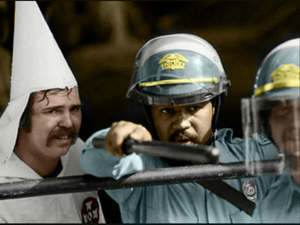 police officer helping a KKK member as a mob of protesters were closing in on their demonstration