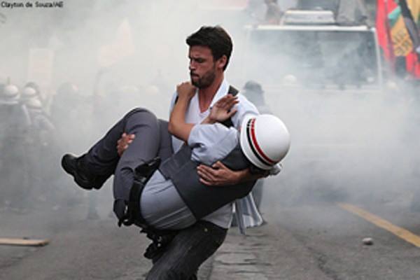 Brazilian protester carrying an injured officer to safety [Sao Paulo, Brazil, 2012]