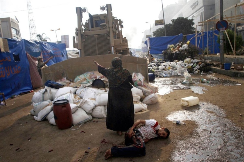 Woman defends a wounded protester from a military bulldozer [Egypt, 2013]