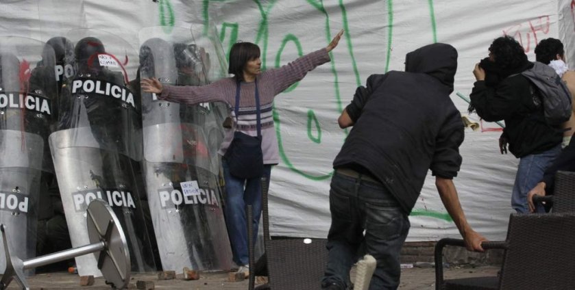 Woman successfully defends a group of cornered riot officers from angry protesters [Bogotá, Colombia, 2013]