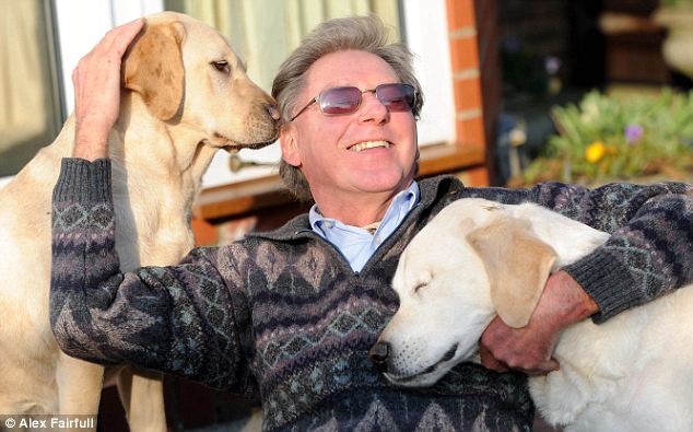 Man (and dog's) best friend: Graham Waspe cuddles up with guide dog Opal (left) and Edward at his home  