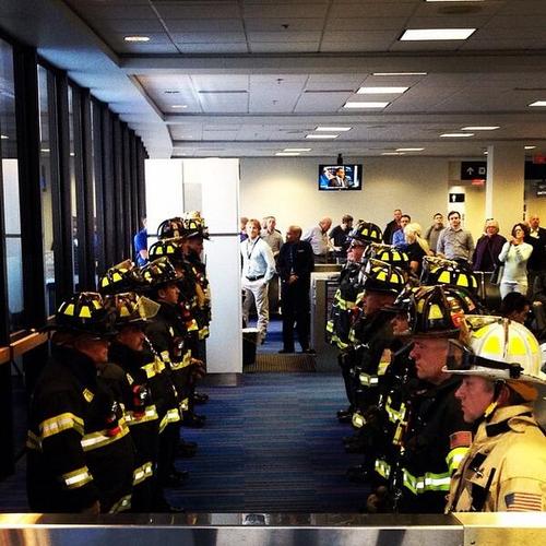 members of the Massachusetts Port Authority’s Fire Department stood by at Logan Airport to meet the family of one of their fallen comrades