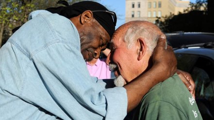 two homeless men hugging