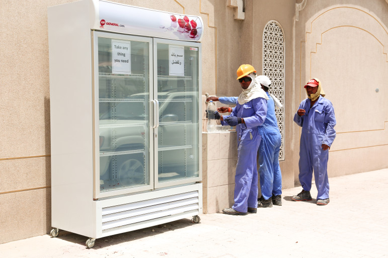 Local Qatari family stocks outdoor fridge with free cold drinks