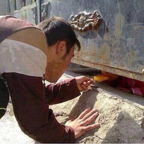 "Man comforting trapped child with ice cream, after a TNT attack on Aleppo while awaiting for help."