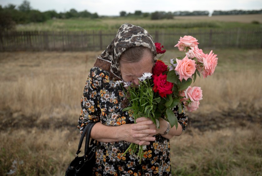 A local woman praying at the MH17 crash site, Donetsk oblast, Ukraine [3000x2019]