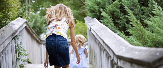 Woman walking over bridge with girl