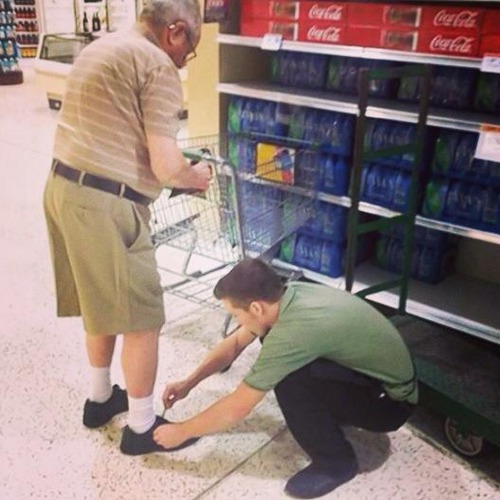 helping an elderly man tie his shoe