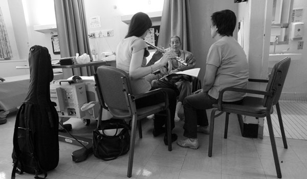 Ms. Travers ,with the help of a nursing aide who translates and sings, encourages Kui San Fung to close his eyes, and open his mind. “Forget the nursing home," she says. "Imagine the scenes in the song.“