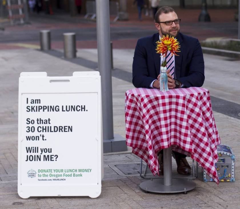 Portland man skips his lunch to raise money, awareness for Oregon Food Bank Anton Cobb, 32, sits alone in Director's Park during his lunch hour every Wednesday at a table decorated with a red and white checkered tablecloth.
