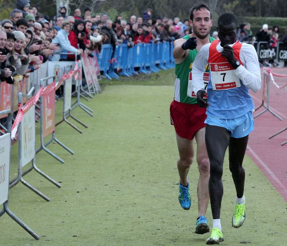 Fernández Anaya helps Mutai toward the line. / CALLEJA (DIARIO DE NAVARRA)