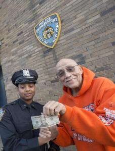 Lemuel (Bill) Copeland, left, pays back NYPD Officer Marvin Luis the $20 the cop gave him.