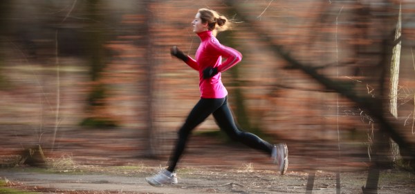 Young woman running outdoors in a city park