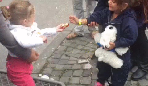 A young German girl greets a newly arrived young refugee girl