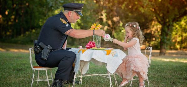 Little girl has tea party with police officer who saved her life after she choked on a coin
