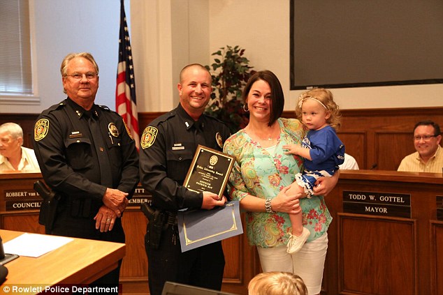 Local hero: Officer Ray was presented with the Rowlett Police Department's Life-Saving Award from Police Chief Brodnax last year. The Norvells were on hand for the ceremony