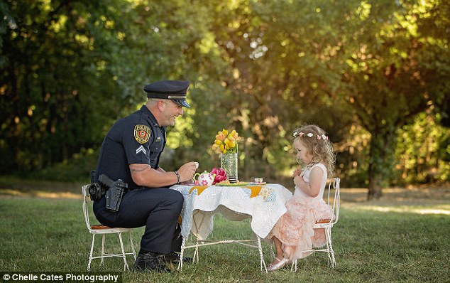 Tea for two: Police Corporal Patrick Ray, from Rowlett, Texas, is pictured at a tea party with 2-year-old Bexley Norvell whose life he saved a year ago 